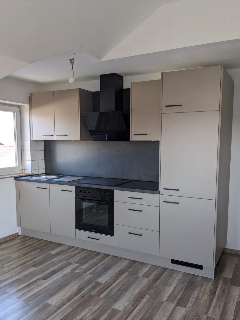 Küche in modernem Design aus Altholz und Fronten in schwarz